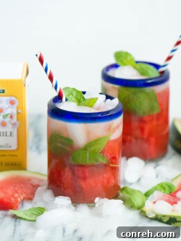 Watermelon Chamomile Iced Tea with Basil in a glass with watermelon chunks and basil garnish