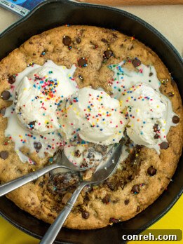 Gooey Mexican Chocolate Chip Skillet Cookie topped with ice cream and sprinkles