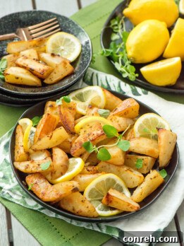 Golden-brown lemon butter potatoes garnished with fresh herbs and lemon slices