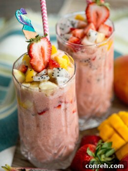 A vibrant pitcher of Agua de Frutas, brimming with fresh fruit pieces and ice, ready to be served.