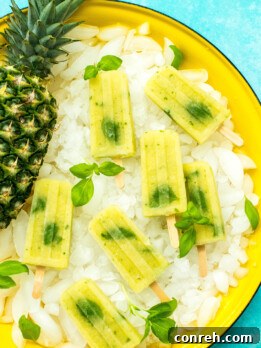 Pineapple Basil Refreshers 2 A vibrant close-up of Pineapple Basil Paletas, glistening with frost, ready to be enjoyed on a hot summer day.