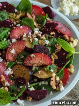 Vibrant Plum and Beet Salad with Spinach and Feta, showcasing fresh ingredients and a rich purple hue.