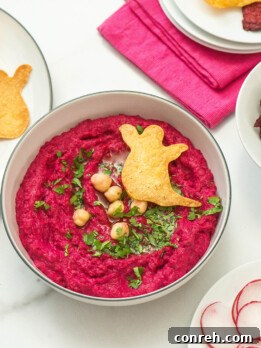 Vibrant pink beet hummus with Halloween-shaped tortilla chips