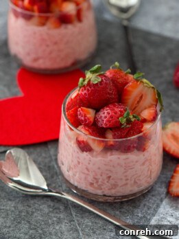 A vibrant bowl of Strawberry Arroz con Leche, garnished with fresh strawberries.