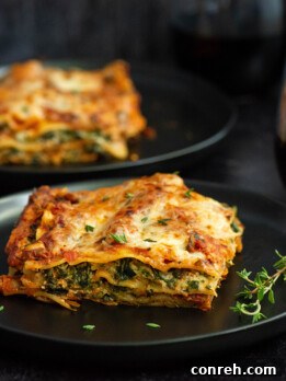 A freshly baked meatless spinach lasagna with a rich red mushroom sauce, ready to be served.