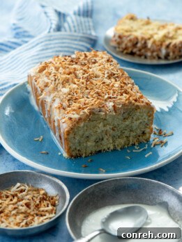 Deliciously moist Coconut Buttermilk Pound Cake on a cooling rack, drizzled with a sweet coconut glaze and sprinkled with toasted coconut flakes.