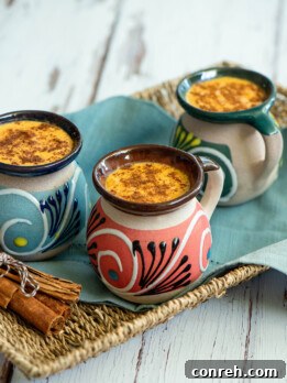 A warm mug of Pumpkin Atole garnished with a cinnamon stick, perfect for autumn evenings.