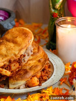 A plate of crispy Tacos Envenenados, garnished with fresh cilantro and a side of salsa.