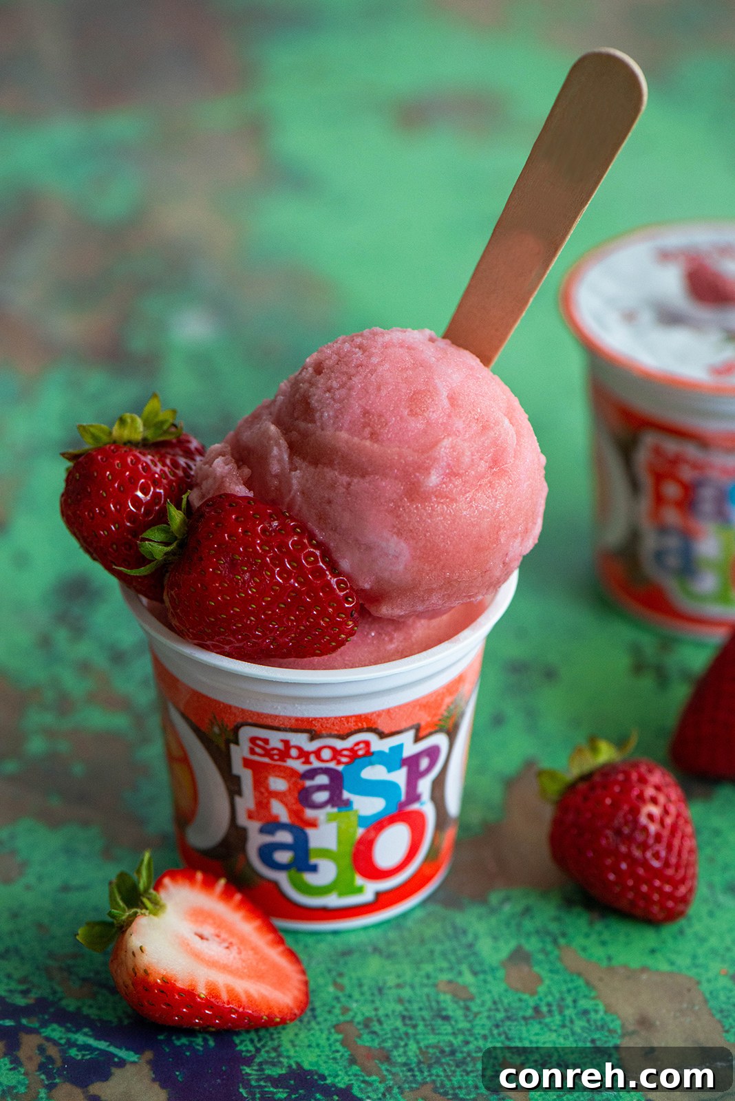 Flavorful Shaved Ice 5 A hand holding a Sabrosa Raspado cup, showcasing the convenient individual packaging.