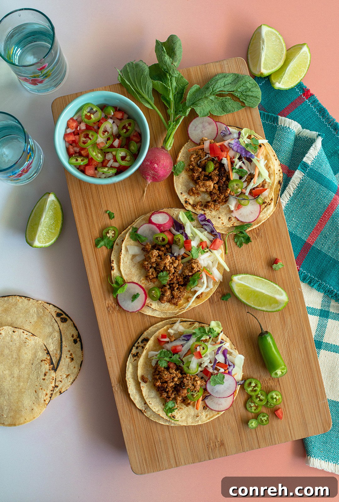 Overhead shot of two complete tofu street tacos on a white background.
