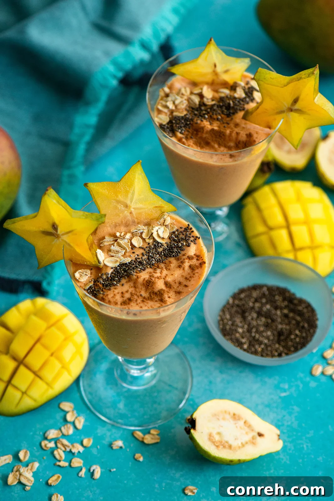 A refreshing Mango Guava Smoothie, vibrant in color, topped with fresh fruit and a hint of spice, presented in a tall glass.