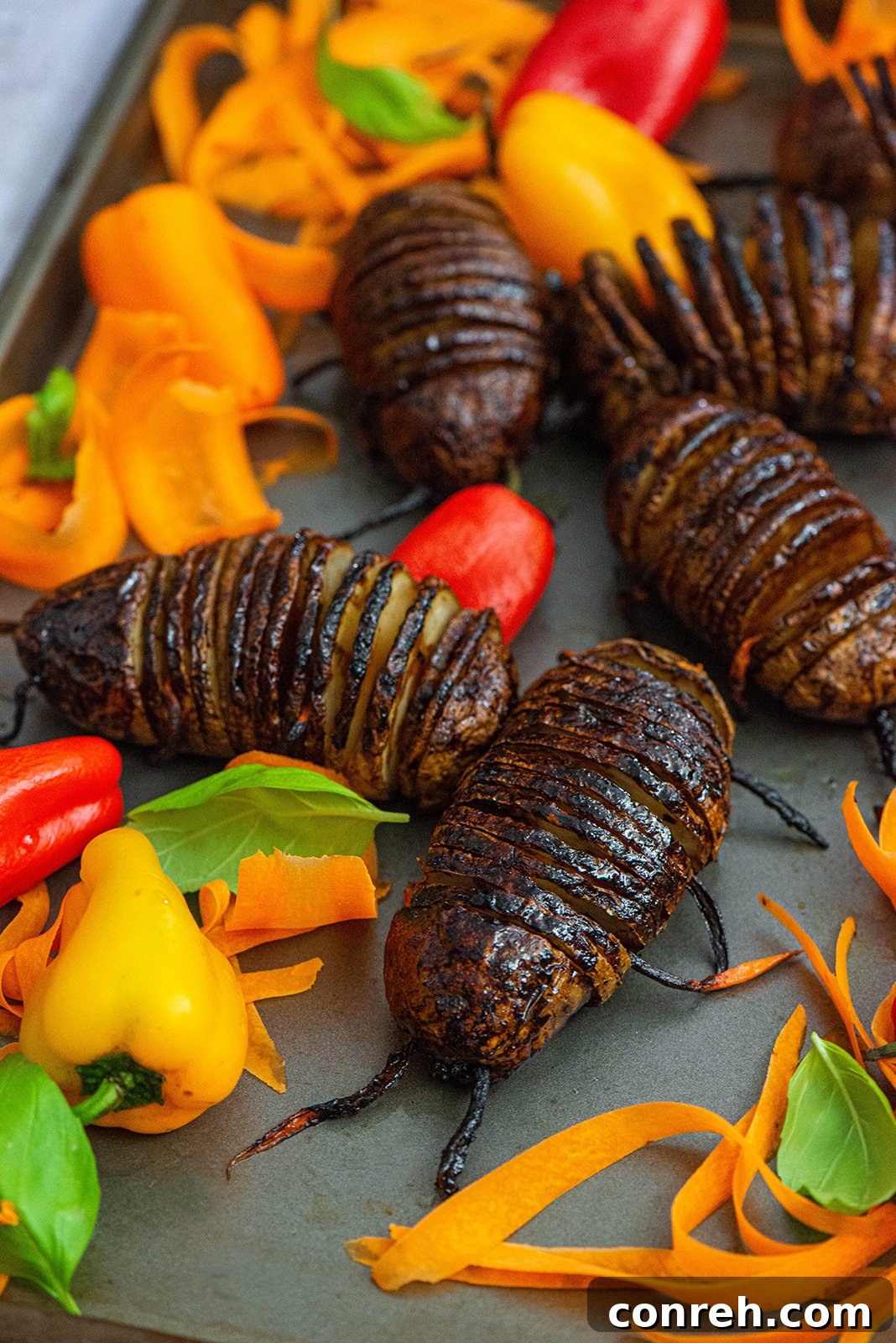 Close-up of Hasselback potato bugs on a serving platter, showcasing their creepy details.