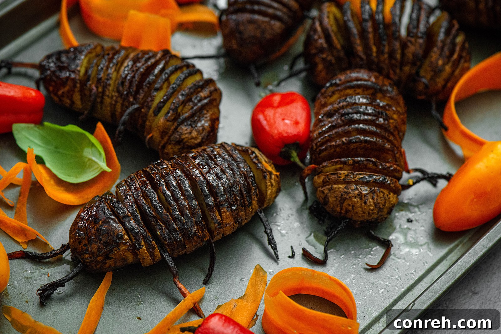 Close-up view of crispy, brown Hasselback Potato Bugs with carrot 'legs' and 'antennae'
