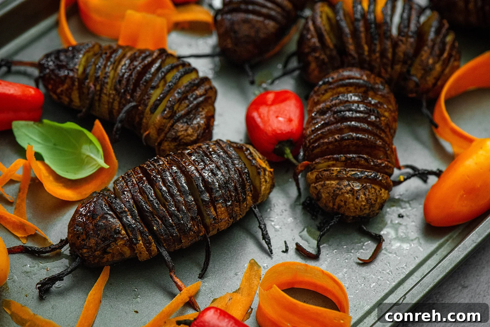 Hasselback potato bugs arranged creatively with carrot sticks acting as legs and antennae.