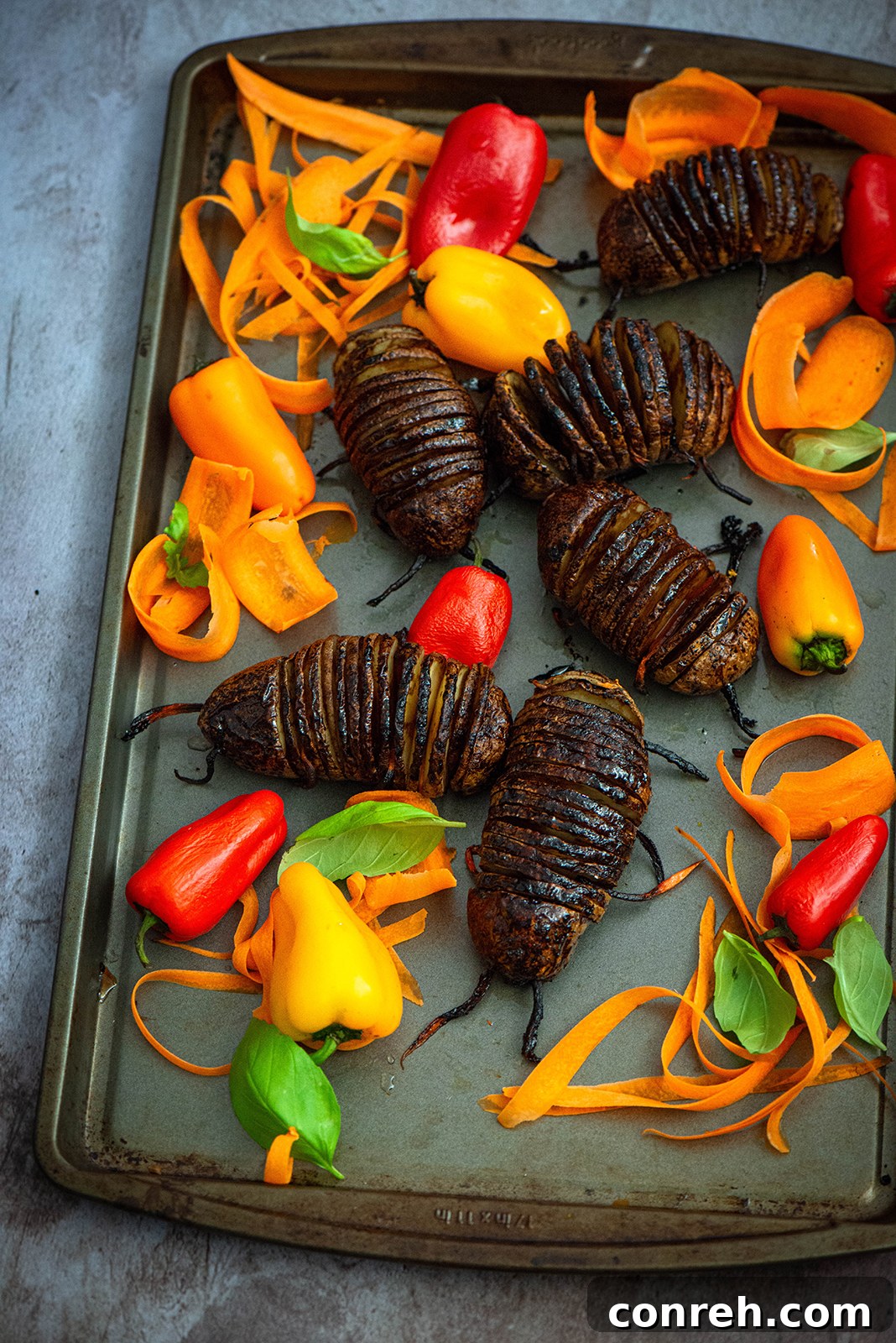 Halloween party display featuring Hasselback Potato Bugs nestled among various chopped vegetables like a 'compost bin'