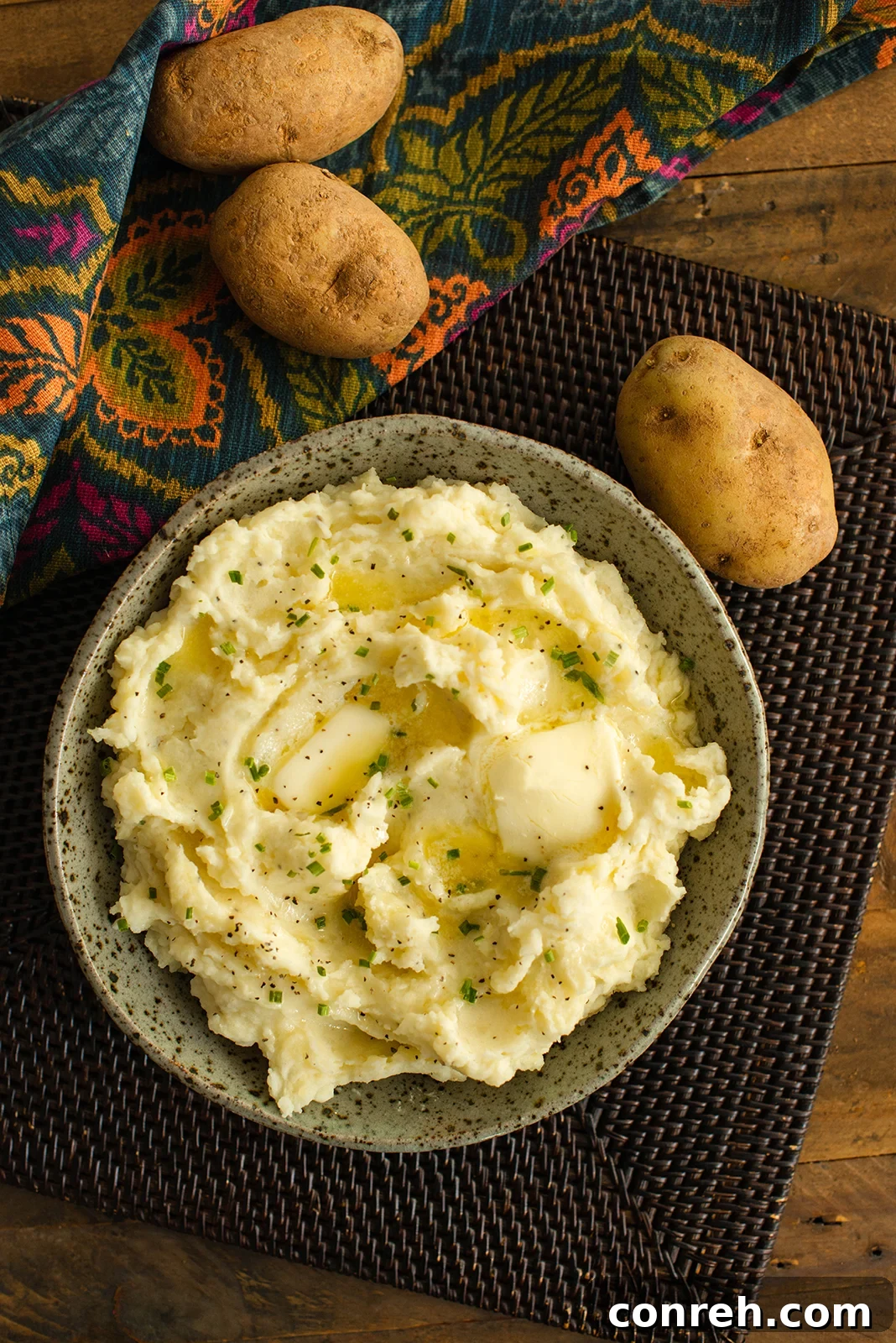 Dreamy Mashed Potatoes 2 A festive table setting with a bowl of creamy mashed potatoes in the foreground, ready for a holiday meal.