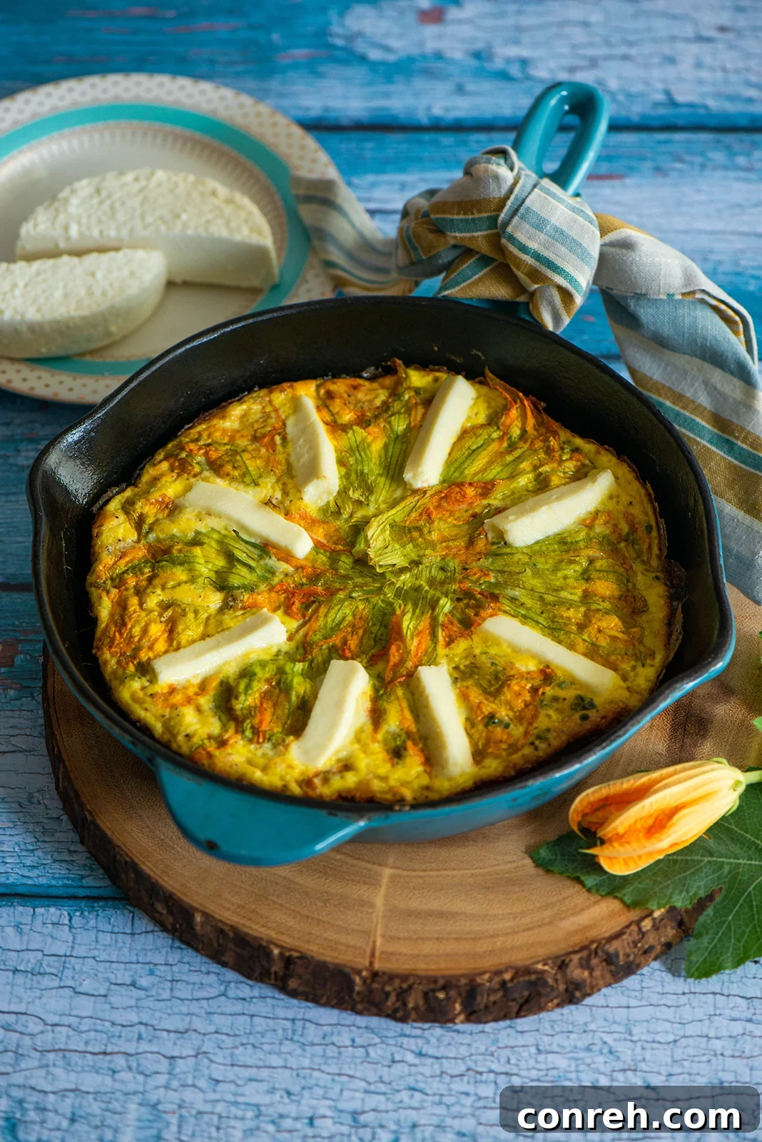 A beautifully set holiday breakfast table featuring a large frittata with fresh ingredients.