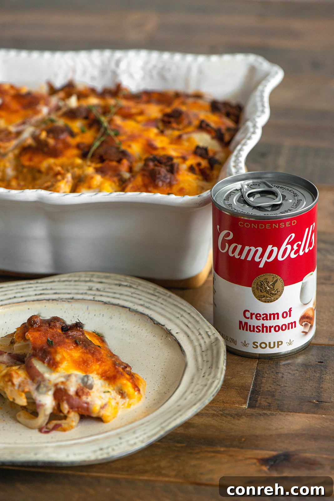 Preparing the scalloped potatoes, showing layers of potatoes, chorizo, and cheese.