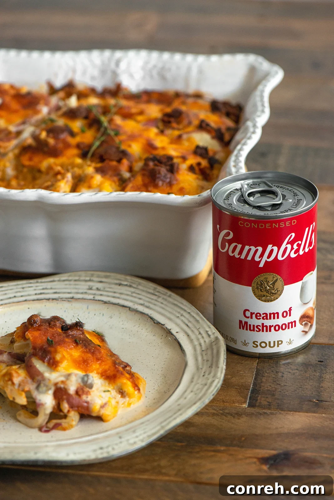A side view of the scalloped potato casserole, showing the distinct layers of potatoes, cheese, and chorizo, with the creamy sauce visible.