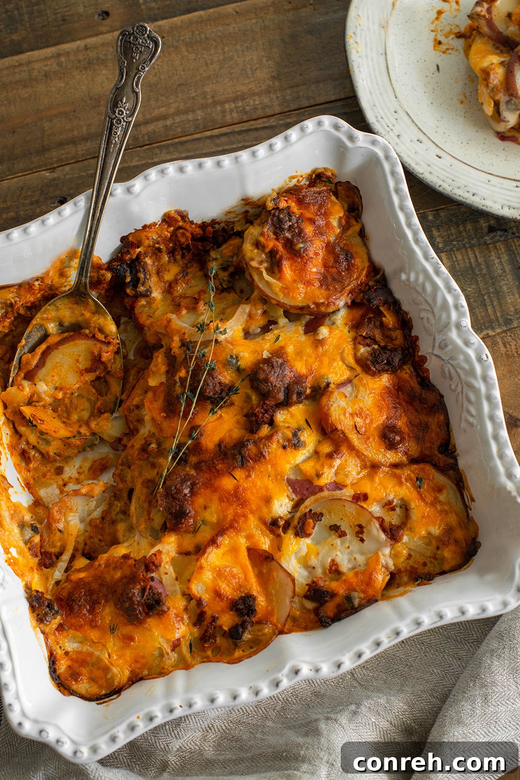 A serving of cheesy scalloped potatoes with chorizo on a plate, ready to enjoy.