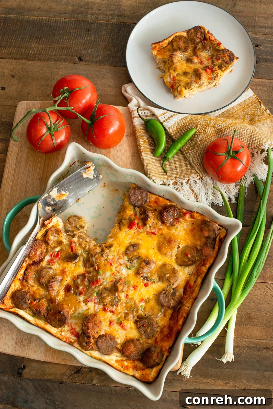 Delicious overnight breakfast casserole with sausage and pico de gallo, topped with herbs