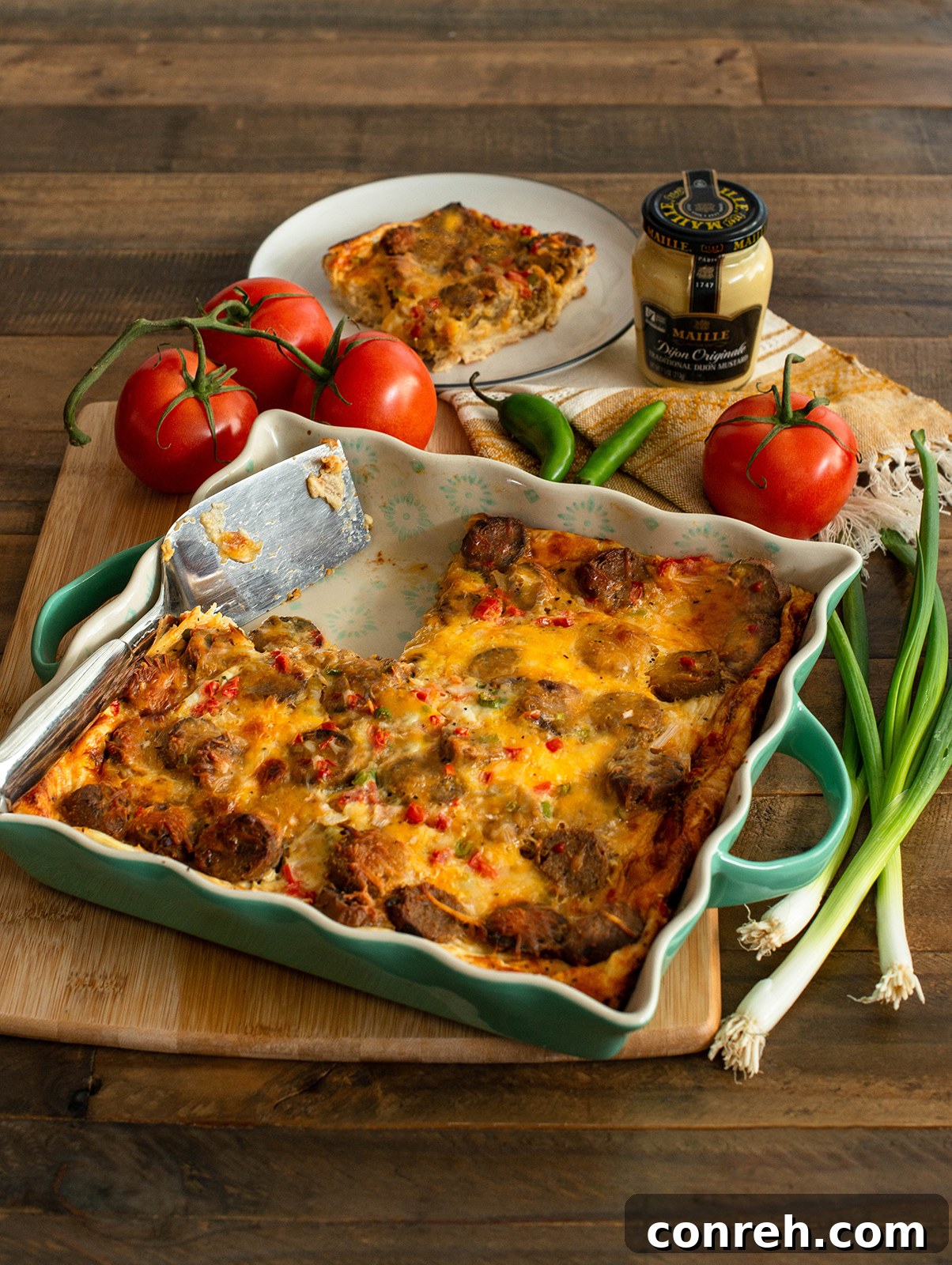 Sliced overnight breakfast casserole with sausage and pico de gallo on a serving dish
