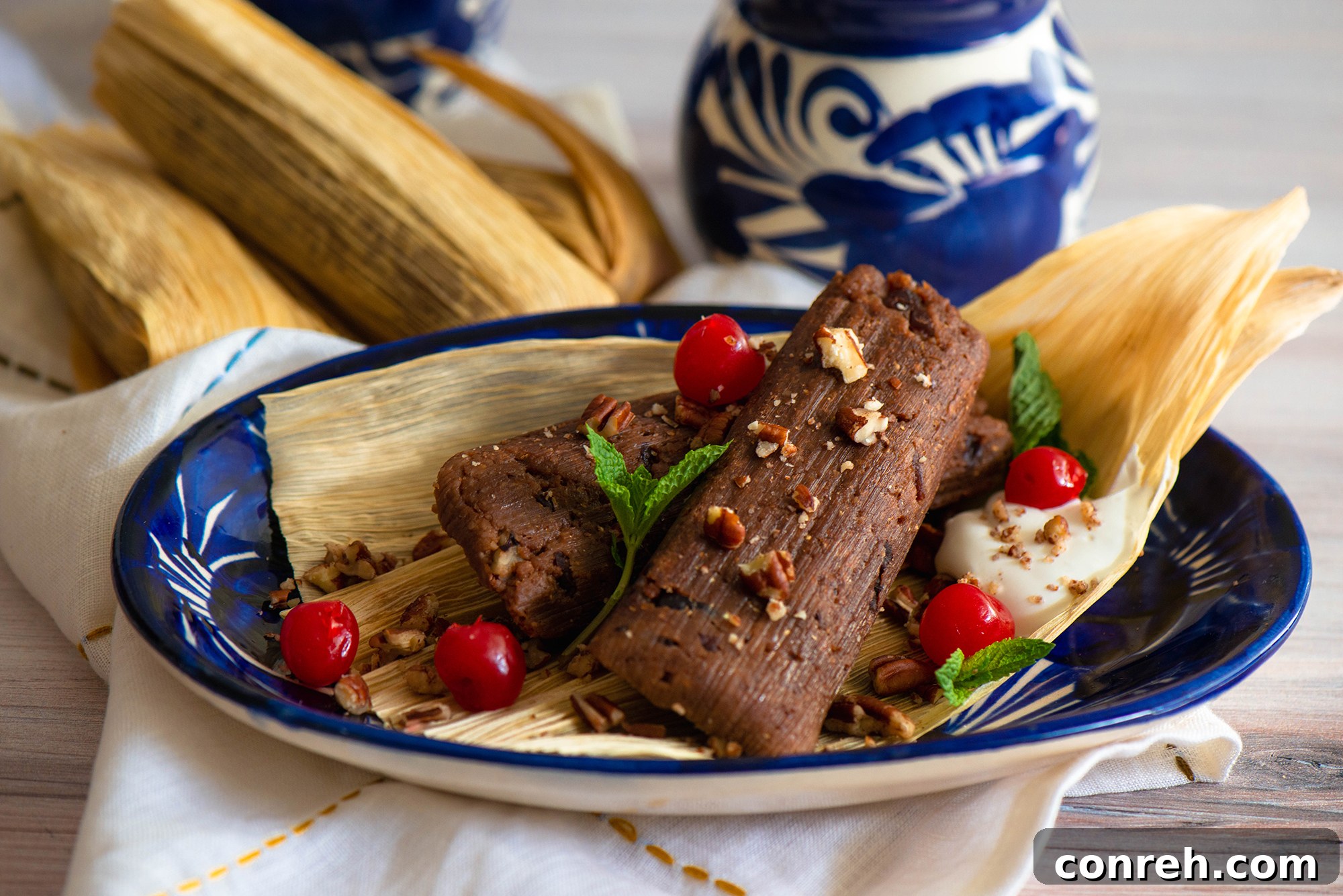 Close-up of freshly prepared Chocolate Cherry Tamales, garnished with whipped cream, maraschino cherries, and mint