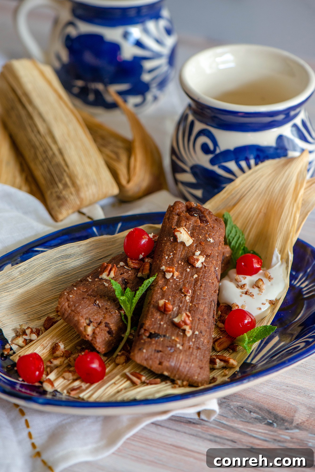 A stack of golden brown Coricos, a traditional Mexican corn cookie, next to Chocolate Cherry Tamales