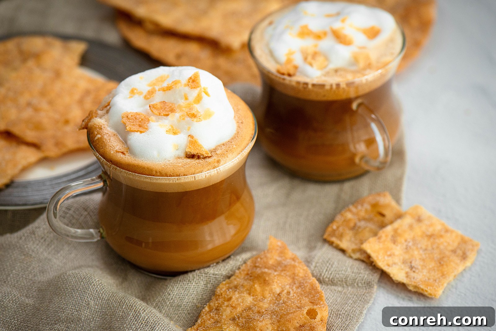 A vibrant Salted Egg Yolk Latte garnished with buñuelo crumbles, showcasing its creamy texture and inviting aroma.