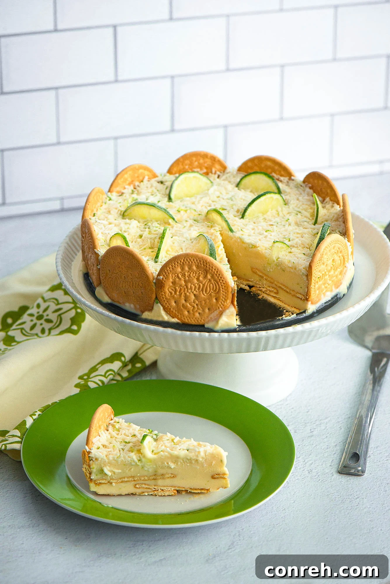 Freshly made Coconut Lime Carlota, garnished with lime slices and shredded coconut, against a blurred spring background.