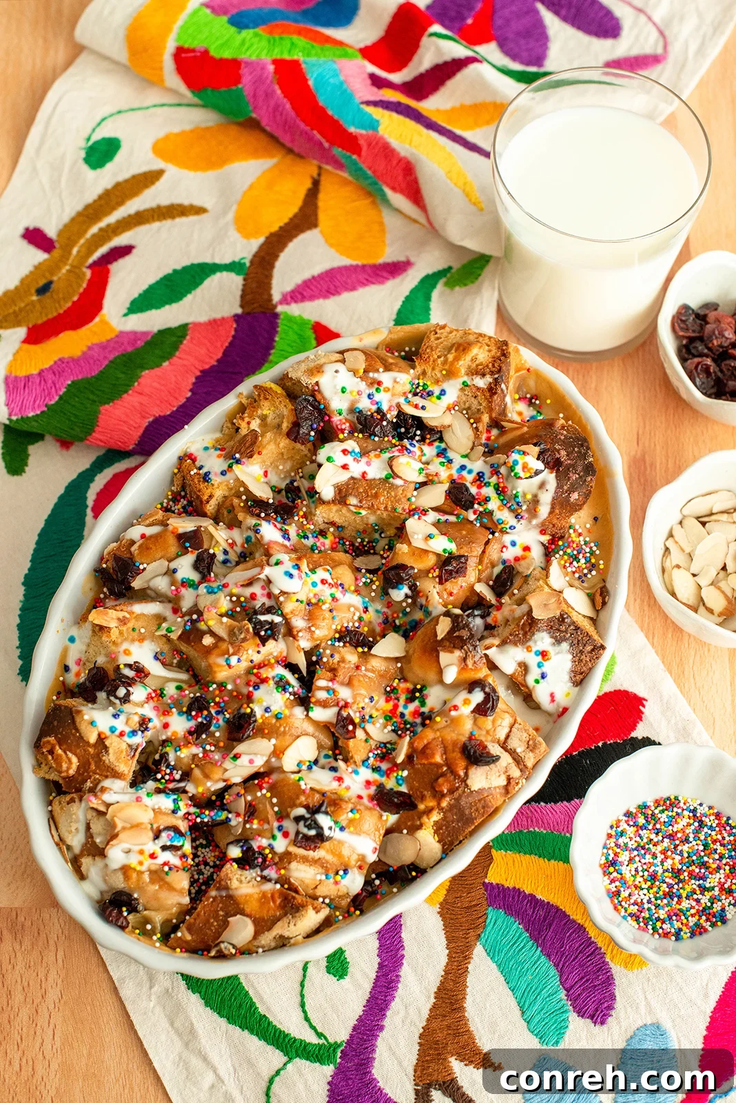 A beautifully plated Capirotada with a modern twist, featuring pan dulce and a creamy, rich sauce, garnished with nuts.