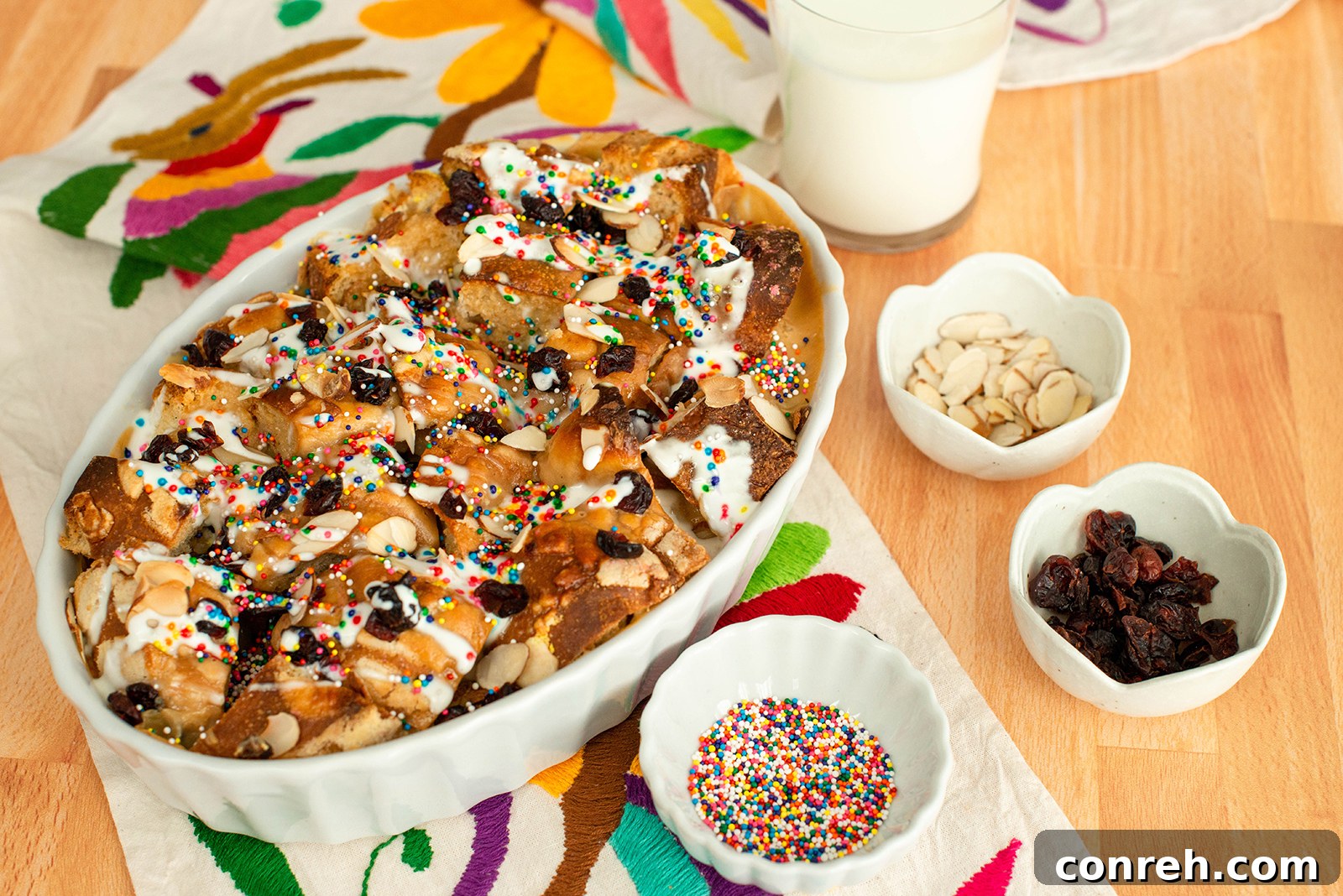 Close-up of the Tres Leches Capirotada, showcasing the creamy texture, pan dulce pieces, and various toppings.