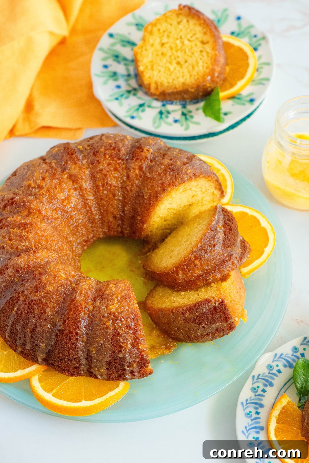 Freshly baked orange cake on a cooling rack, garnished with orange slices.