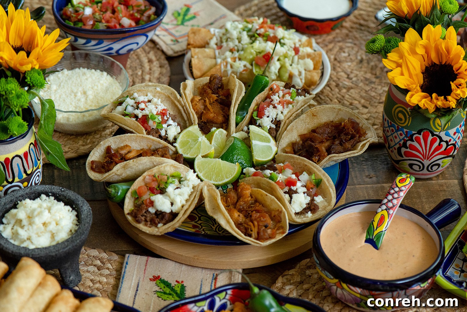 A wide shot of a taco table showing the full array of food and decorative elements.