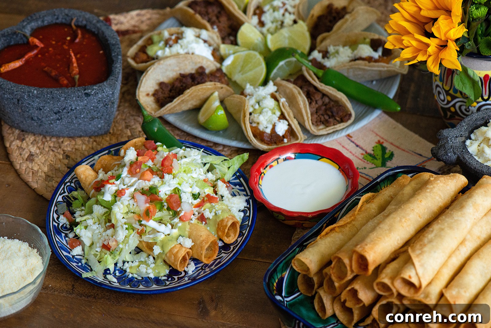 A colorful arrangement of small bowls filled with various taco toppings on a rustic table.