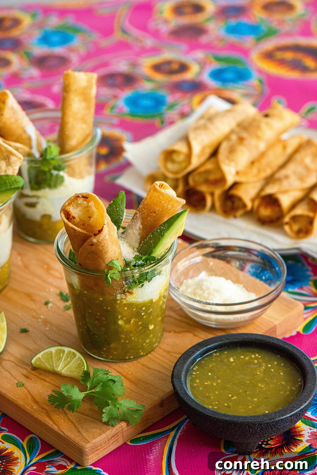 Crispy Taquitos Ahogados drenched in vibrant salsa verde, Real California Milk crema, and cotija cheese, ready for a delicious summer snack.