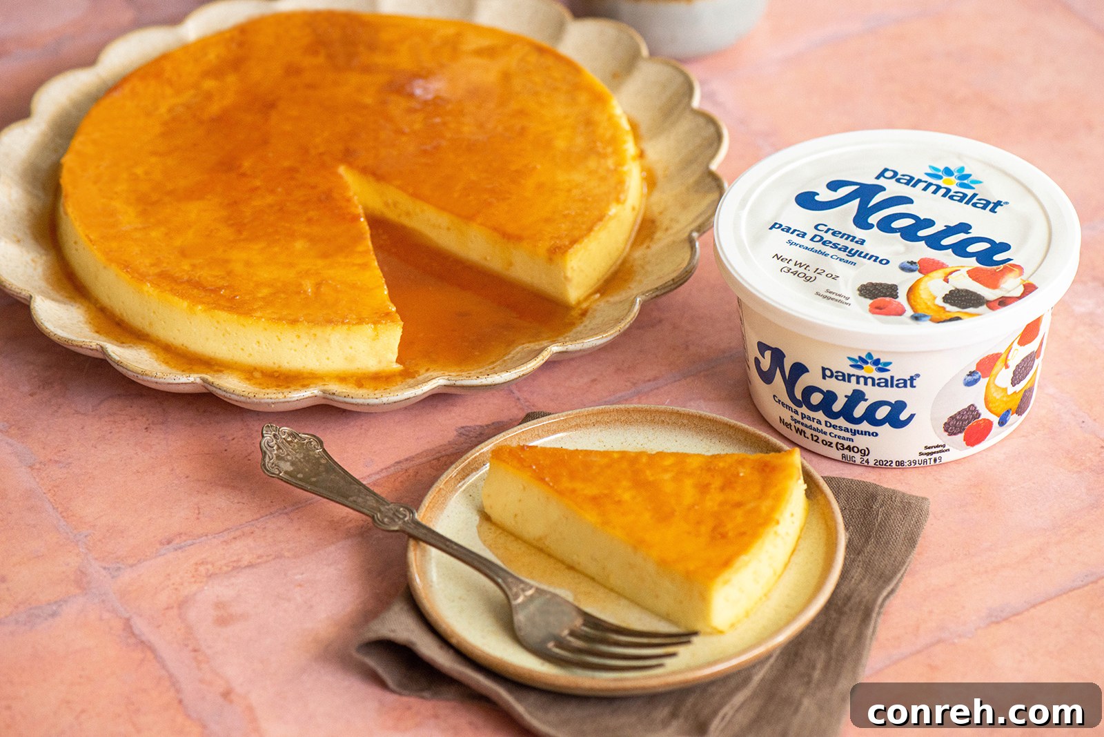 Two pieces of Flan de Nata on plates, garnished with fresh berries and mint