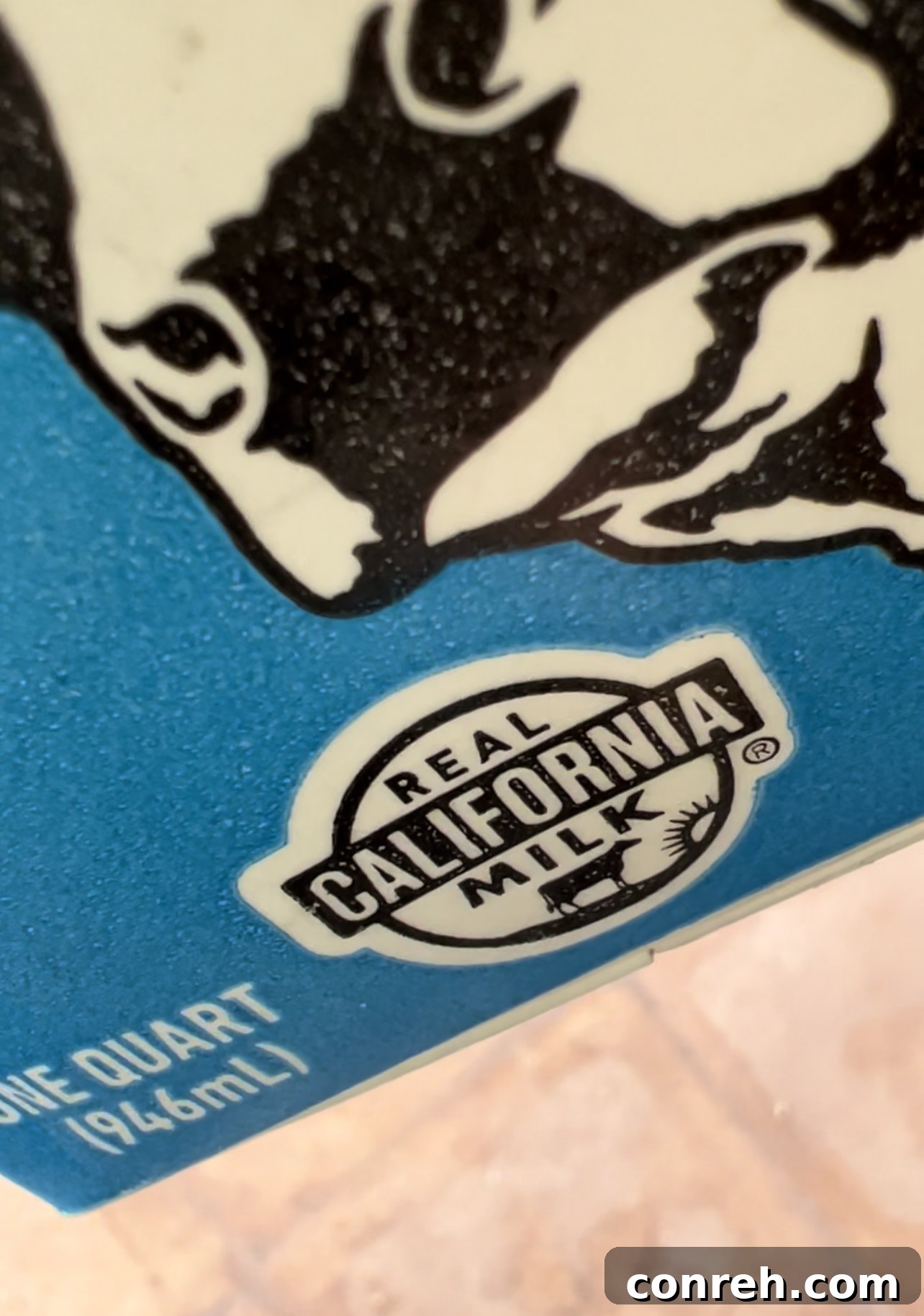 Close-up of golden brown sopaipillas, some split open to reveal their airy interior, next to a bowl of honey and nata filling.