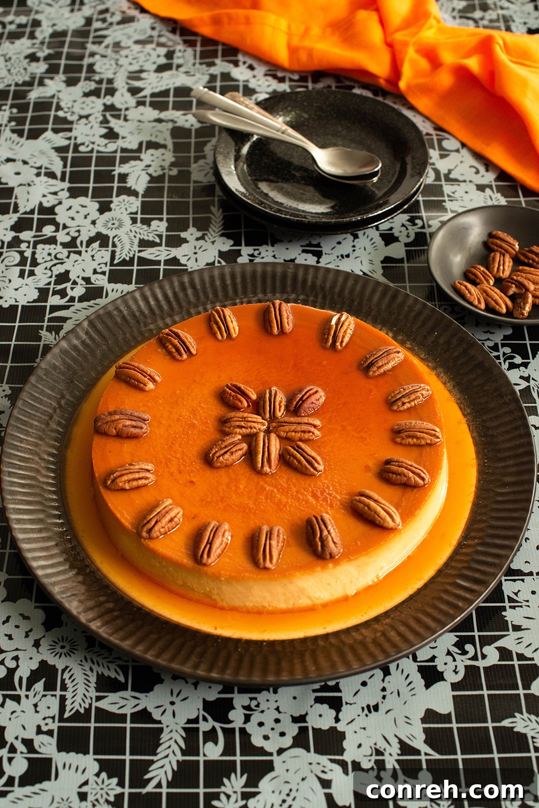 Close-up of a slice of sweet potato flan with caramel and pecans