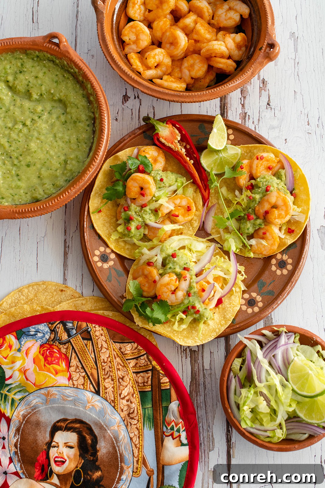 A close-up shot of a beautifully prepared shrimp taco, featuring seasoned shrimp, fresh toppings, and a generous dollop of creamy green chile salsa.