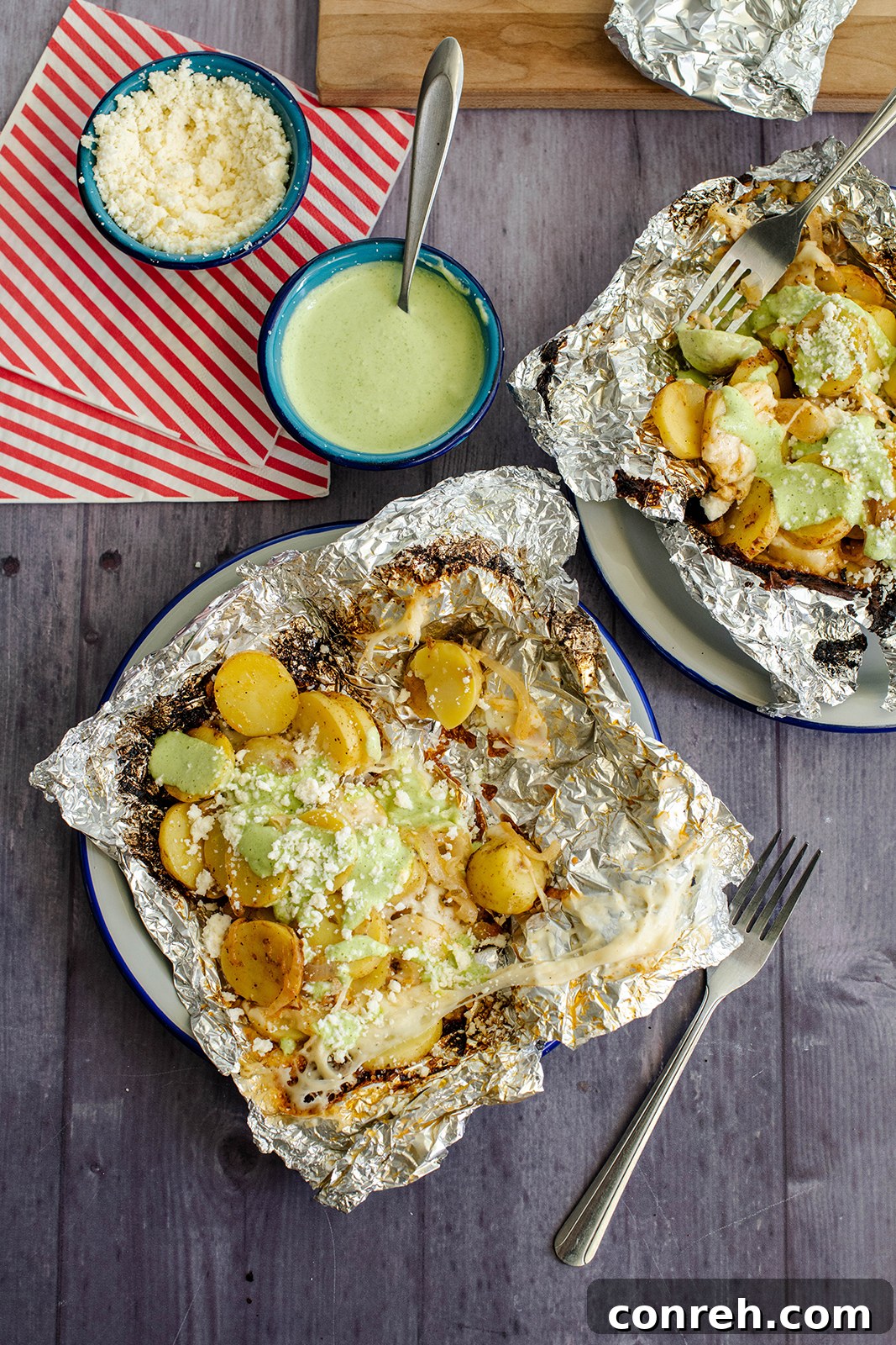 Close-up of Campfire Potatoes with Jalapeño Crema, showing melted cheese and fresh cilantro garnish