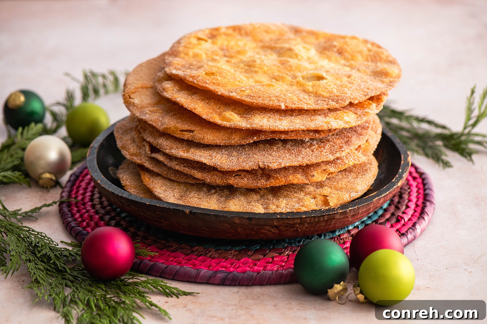Close-up of a crispy Mexican Buñuelo dusted with cinnamon sugar