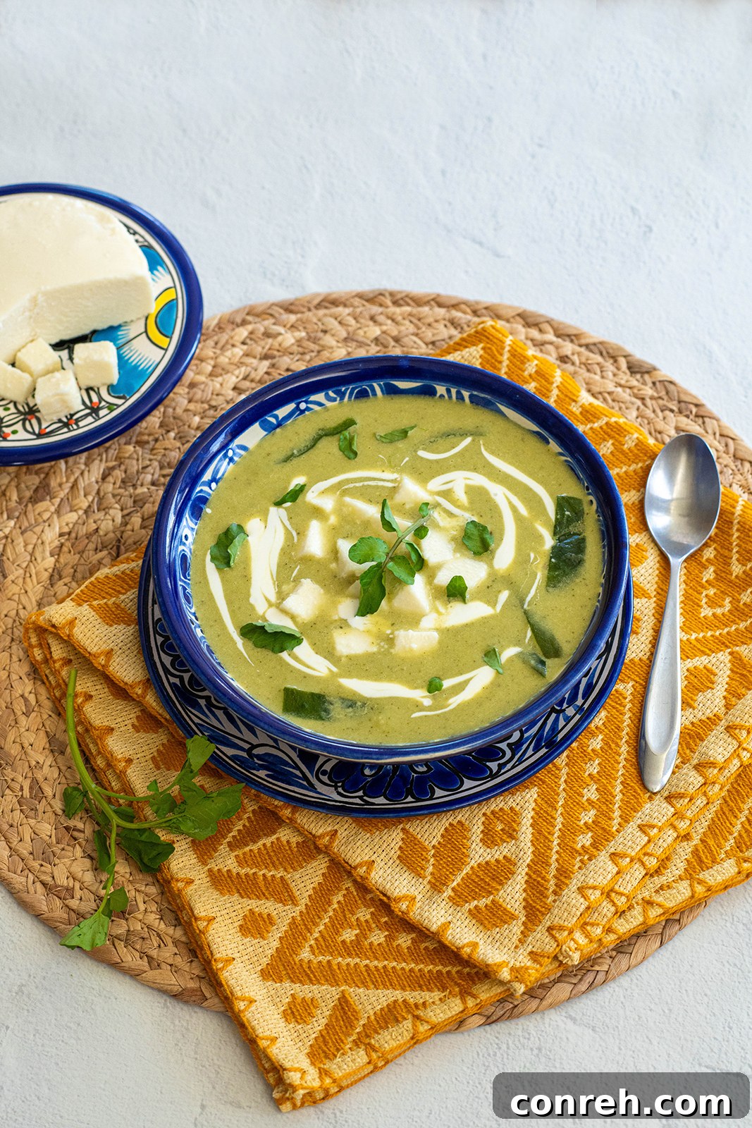A close-up shot of the creamy watercress potato poblano soup, showing its rich texture and garnished with fresh watercress.