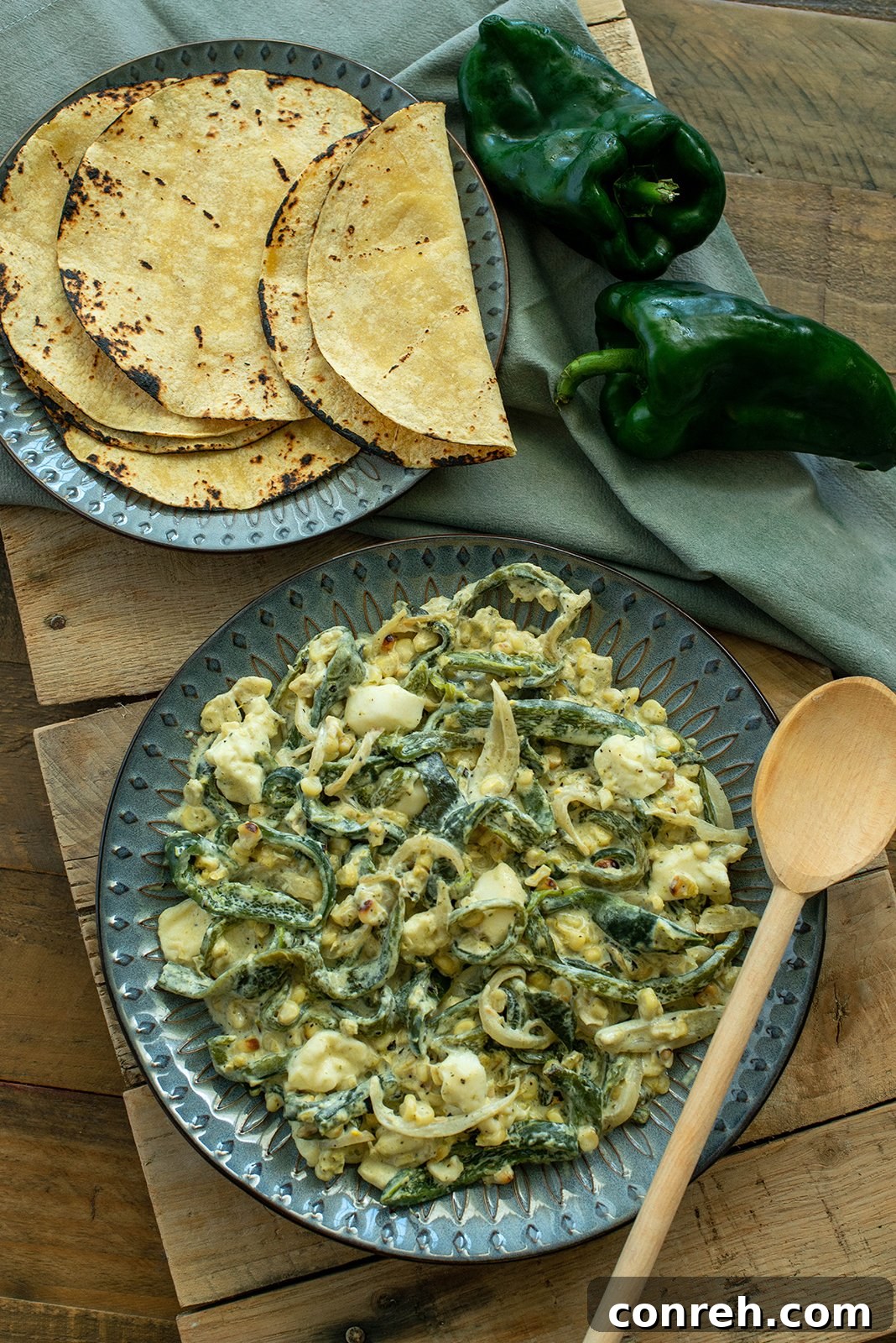 A vibrant bowl of Creamy Poblano Chile Strips, also known as Rajas con Crema, garnished with fresh cilantro and served alongside warm corn tortillas.