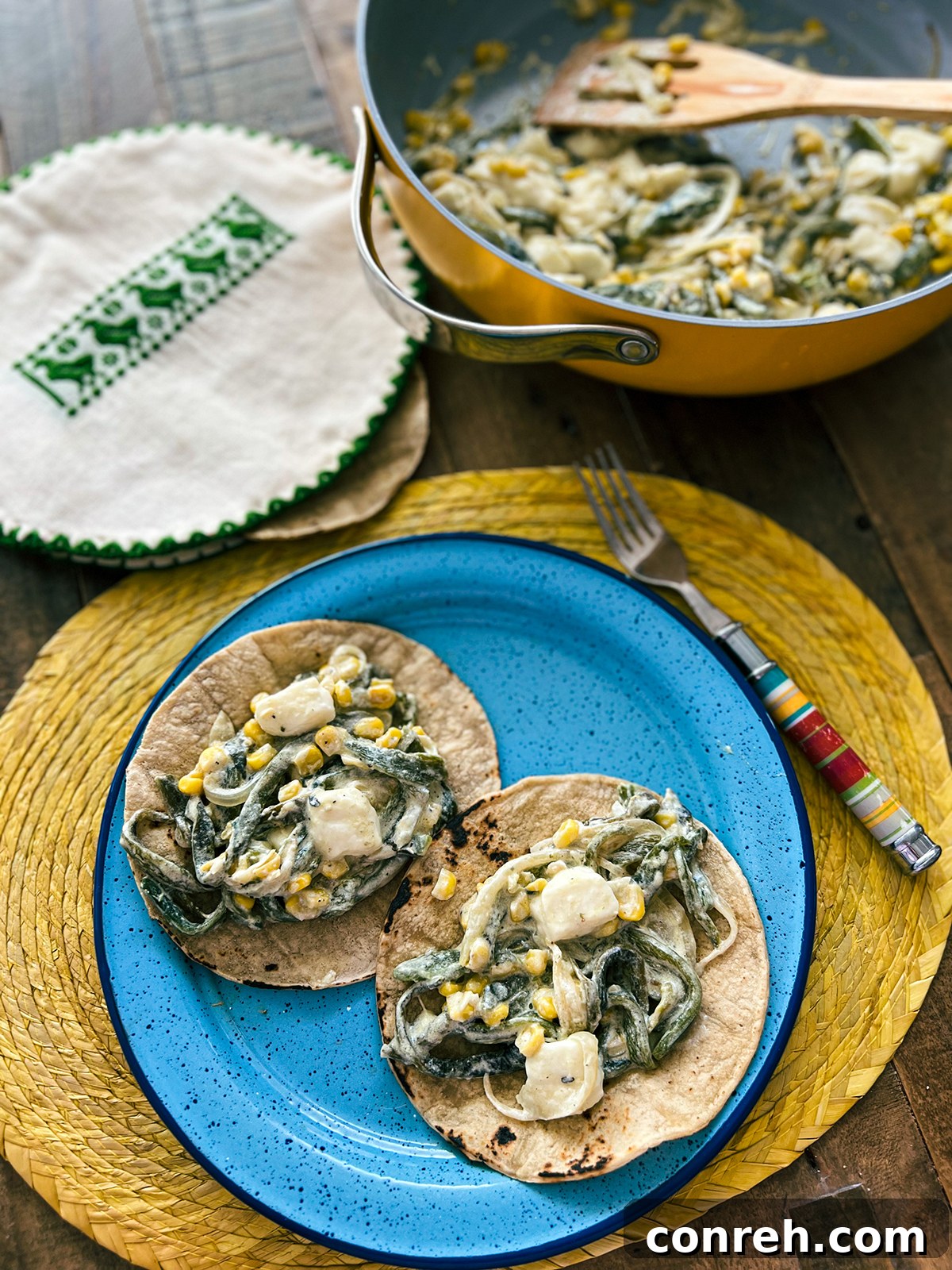 Close-up of Creamy Poblano Chile Strips in a white bowl, showing the creamy texture, roasted poblano pieces, and corn kernels.