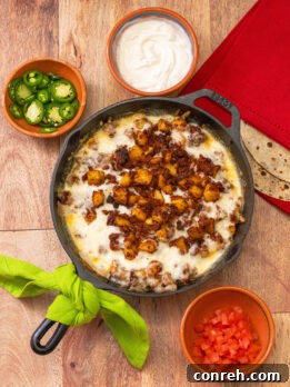 A vibrant close-up of Queso Fundido with melted cheese, chorizo, and potatoes, ready to be scooped.