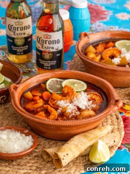 A vibrant bowl of Caldo de Camarón, a traditional Mexican shrimp soup.