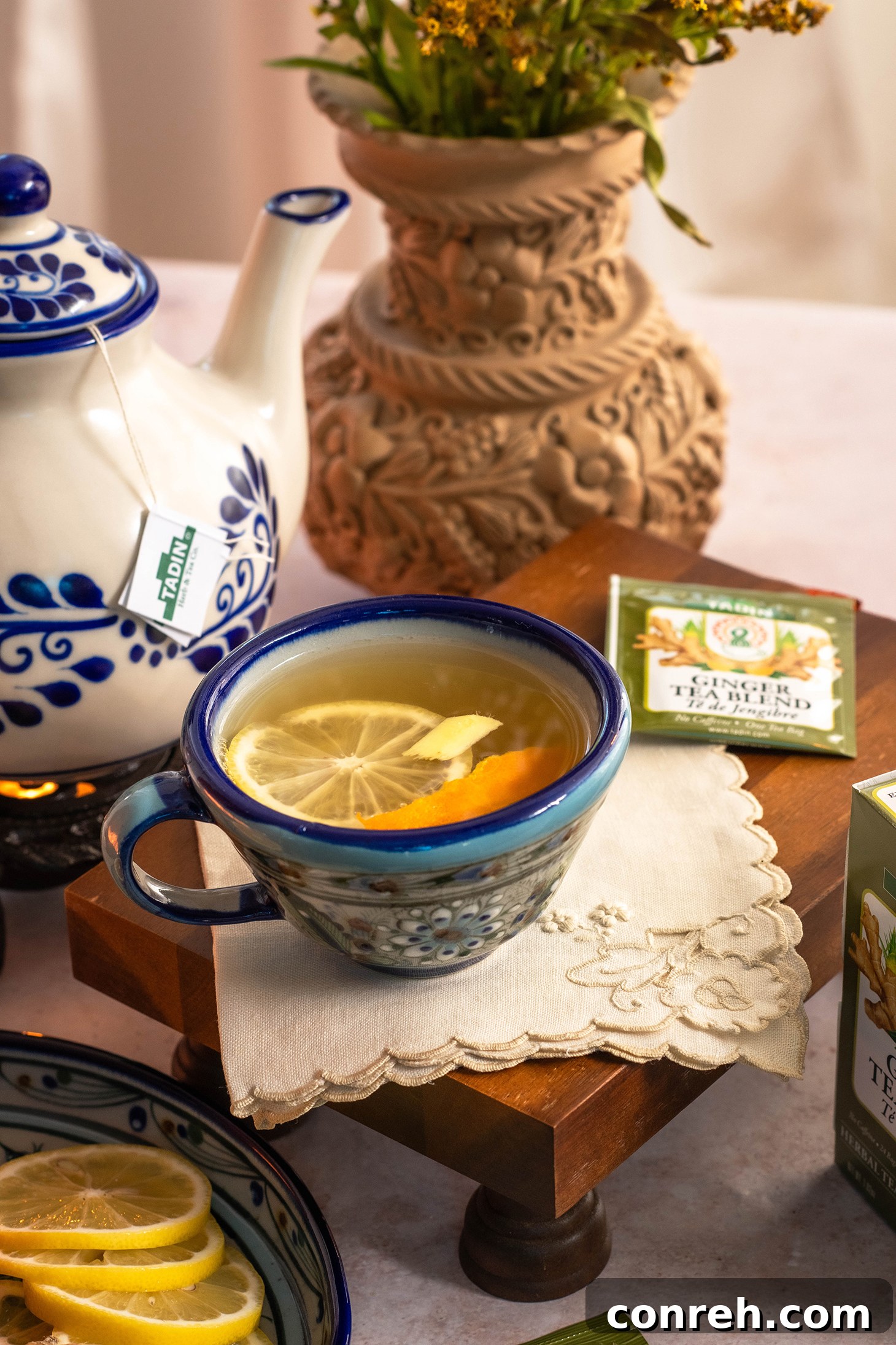 Zesty Piloncillo Ginger Tea 3 Two steaming mugs of Citrus Ginger Tea with Piloncillo Syrup, garnished with fresh orange slices and cinnamon sticks, on a cozy wooden surface.