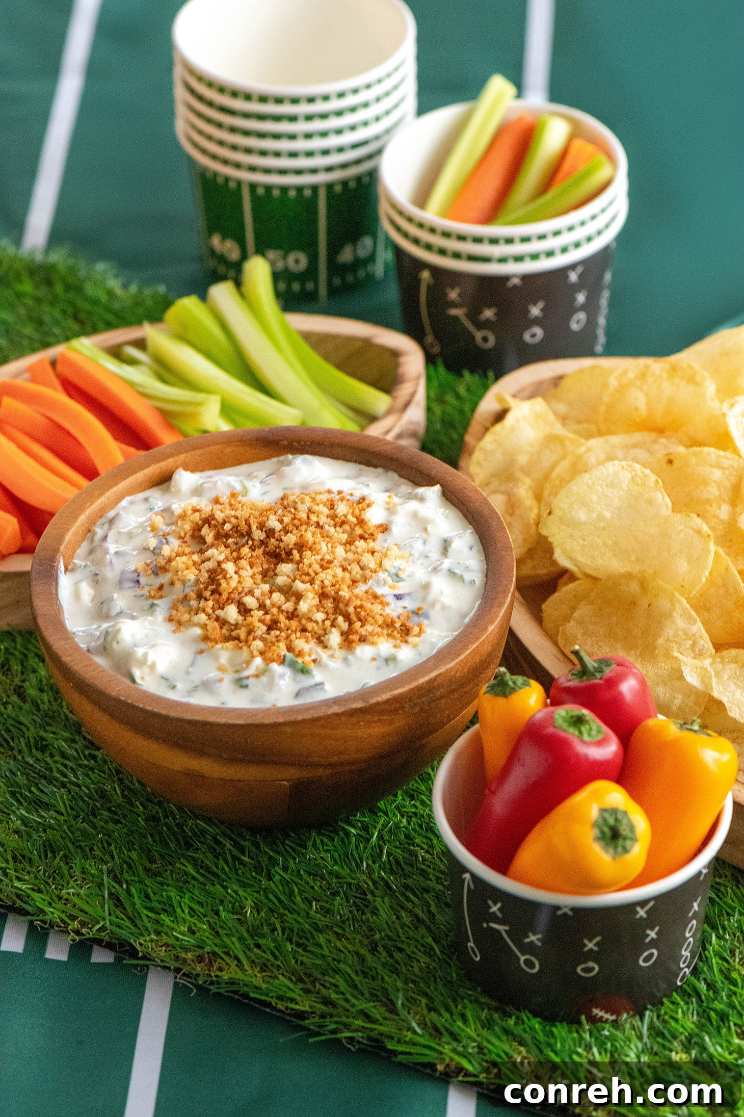 A vibrant bowl of creamy Jalapeño Yogurt Dip, garnished with fresh cilantro and crispy panko crumbs, served with a side of colorful vegetables and tortilla chips.