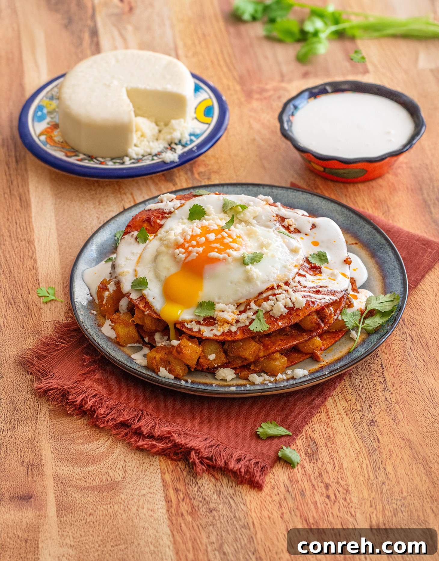 Delicious stacked potato and chorizo enchiladas topped with a fried egg and fresh cilantro.